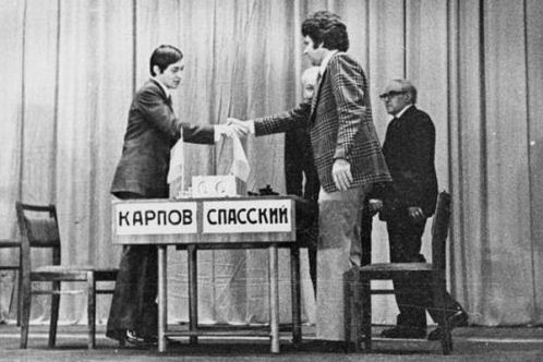 Russian chess grandmasters Boris Spassky, right, and Anatoly Karpov, left,  shake hands the news